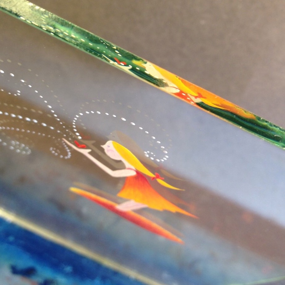 Image was taken in progress of one of my reverse glass paintings and features a girl holding a heart in her hands with her image refracted within the edge of the glass.