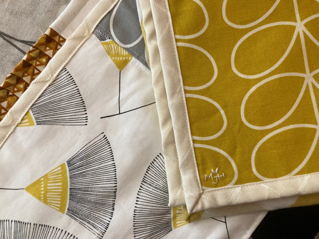 Umage is of a detail from one of my sensory rich quilts folded over to show my makers mark on the corner. My makers mark features my initials ‘MJH’ crowned with a small heart - all done in embroidery thread.